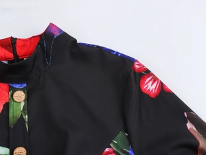 Détail du col montant à imprimé floral et boutons dorés sur la robe longue plissée