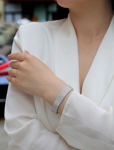 Close-up of a multi-row sparkling silver tennis bracelet worn on a woman wrist