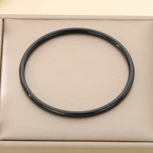 Detailed view of a sleek 3mm black polished stainless steel bangle in a velvet jewelry box