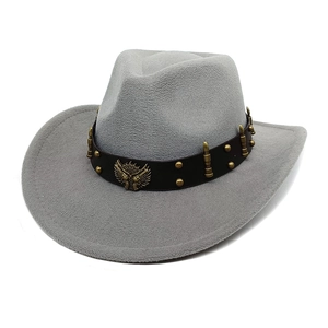 Dettaglio cappello da cowboy grigio con fascia in pelle e stemma decorativo con aquila