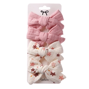 Detail of 4-piece bow hair clip set with floral patterns on a display card