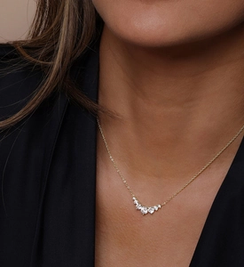 Macro shot of a gold S925 silver smile necklace with white zircon stones on collarbone
