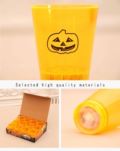 Macro detail of Halloween LED candle cups with pumpkin face and bottom battery switch