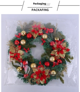 Christmas wreath with red poinsettias and ornaments in transparent packaging for storage