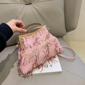 Detail of pink vintage evening bag with shimmering sequins, tassels and gold handle