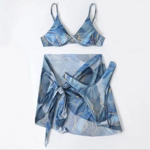 Three-piece bikini set with blue marble print and ribbed fabric in a flat lay view