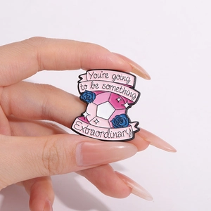 Broche en émail avec gemme rose et roses bleues tenue par une main en gros plan