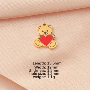Detailed view of golden teddy bear pendant with a red heart and size parameters