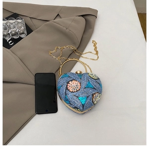 Blue sequined heart-shaped evening bag shown next to a smartphone for size reference