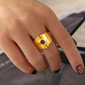 Adjustable gold stainless steel ring with red zircon stone worn on finger