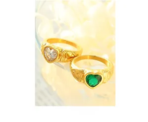 Detailed shot of heart-shaped crystal rings in gold plating with floral background