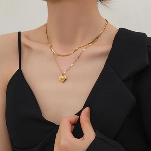 Double-layered gold titanium necklace featuring a heart pendant and sleek snake chain