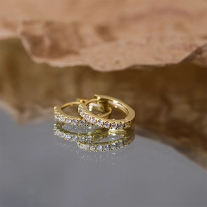 Macro shot of gold S925 sterling silver square hoop earrings with sparkling small diamonds