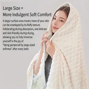Soft creamy white coral fleece bath towel with plush cloud texture shown on a model