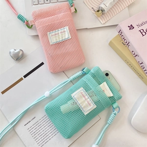 Detail view of mesh phone pouches in pink and mint green with adjustable woven lanyards