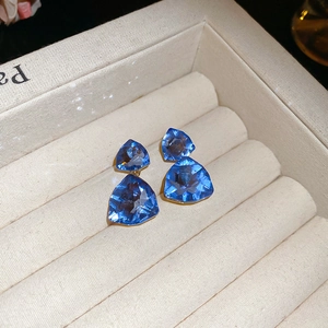 Detail of blue triangular crystal earrings with a two-tier drop design in a jewelry box