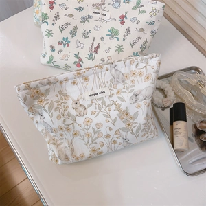 Detailed view of floral canvas makeup bags with rabbit prints and zipper closure