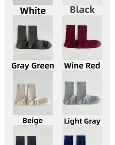 Detail view of cotton crew socks in multiple solid colors with embroidered letter logo
