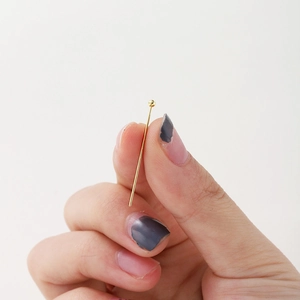 Detailed view of 18K gold-plated ball head pins for DIY jewelry making and beading projects