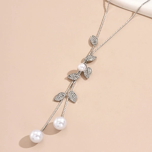 Detail of silver long necklace featuring rhinestone leaves and elegant white pearls