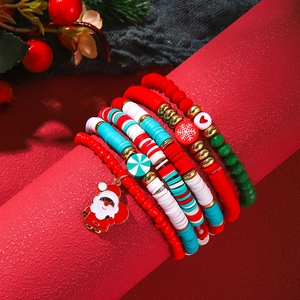 Close-up of festive multi-layer Christmas beaded bracelets with Santa charms on red display