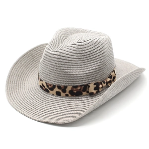 Close-up of woven straw cowboy hat featuring leopard print band and bow detail