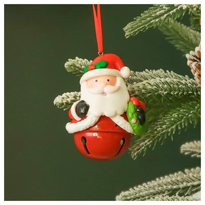 Close-up of a red metal Christmas bell pendant with a painted Santa Claus figure