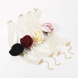 Detailed view of multi-layer pearl necklaces with silk roses in black, red, white, and pink