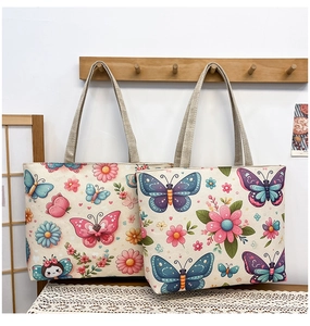 Detail view of ethnic canvas tote bags with colorful floral butterfly prints and woven texture
