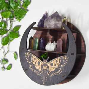 Detail of round wooden Boho shelf with moth carvings holding crystals and minerals