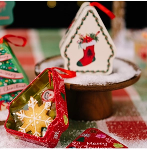 Detail showing red house-shaped Christmas tin box interior and Merry Christmas design