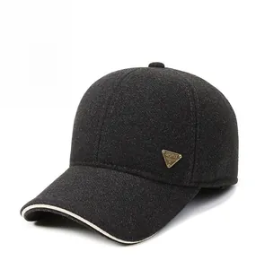 Detail of grey wool baseball cap showing the gold spirit logo and beige brim piping