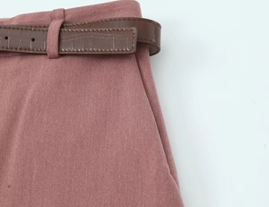 Details von altrosa Baumwollhosen mit einem dunkelbraunen Gürtel in Krokodiloptik