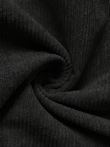 Close-up macro of black corduroy fabric texture for stylish maternity overalls