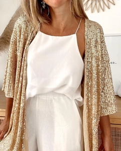 Detail view of the shimmering gold sequin cardigan paired with a white satin top set
