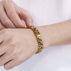 Close-up of golden stainless steel curb chain bracelet with square buckle on wrist