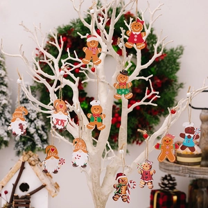 Creative wooden gingerbread man and gnome ornaments hanging on a white Christmas tree branch