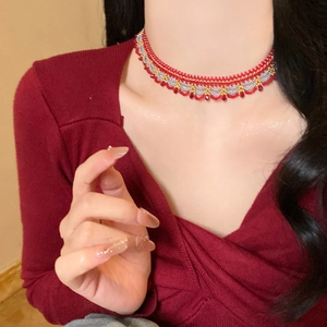 Detail of handcrafted beaded choker with red gold and silver beads in a wavy pattern