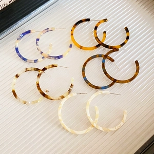 Retro resin C-shaped hoop earrings in tortoise and marble patterns on white tray