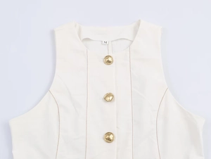Détail du haut blanc sans manches avec surpiqûres marron et boutons dorés élégants