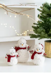 Detailed view of three plush Christmas snowmen with red scarves on a festive tabletop