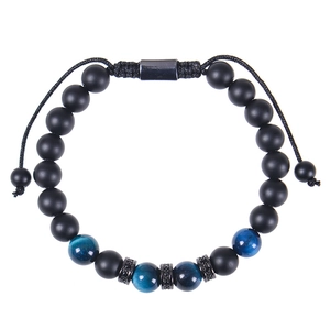 Détail de perles oeil de tigre noires mates et entretoises en zircon sur bracelet ajustable