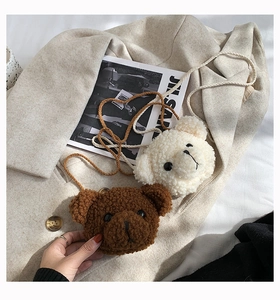 Detail of plush bear crossbody bags in beige and brown on wool coat and magazine