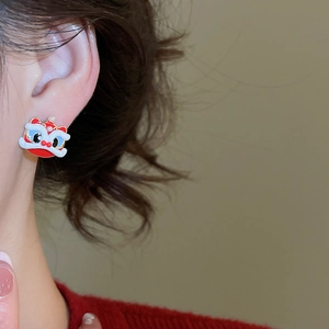Detail of red lion dance stud earring with white fur and blue eyes on model ear