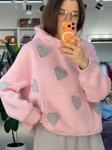 Gros plan détaillé sur la broderie cœur 3D d'un sweat à capuche rose décontracté pour femme