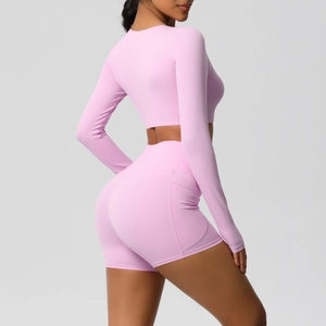 Detailweergave van de roze yogaset met handige zijzak op de korte sportbroek met taille