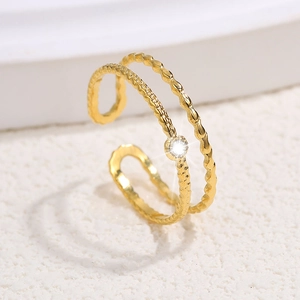 Detailed macro view of the gold double-layered textured ring with a sparkling zircon stone