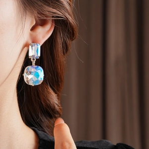 Detail of luxury teardrop square tassel earrings with iridescent crystals on model