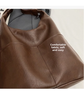 Close-up of vintage brown tote bag showing soft PU leather texture and metal zipper