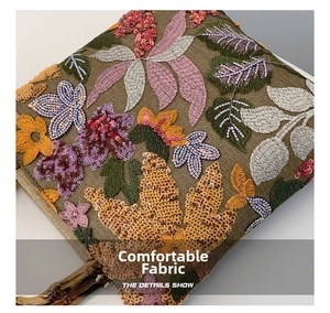Detailed embroidery with sequins on linen fabric and a bamboo handle of the handbag